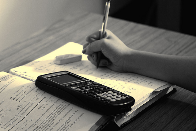 Notebook with math calculations and a claculator.